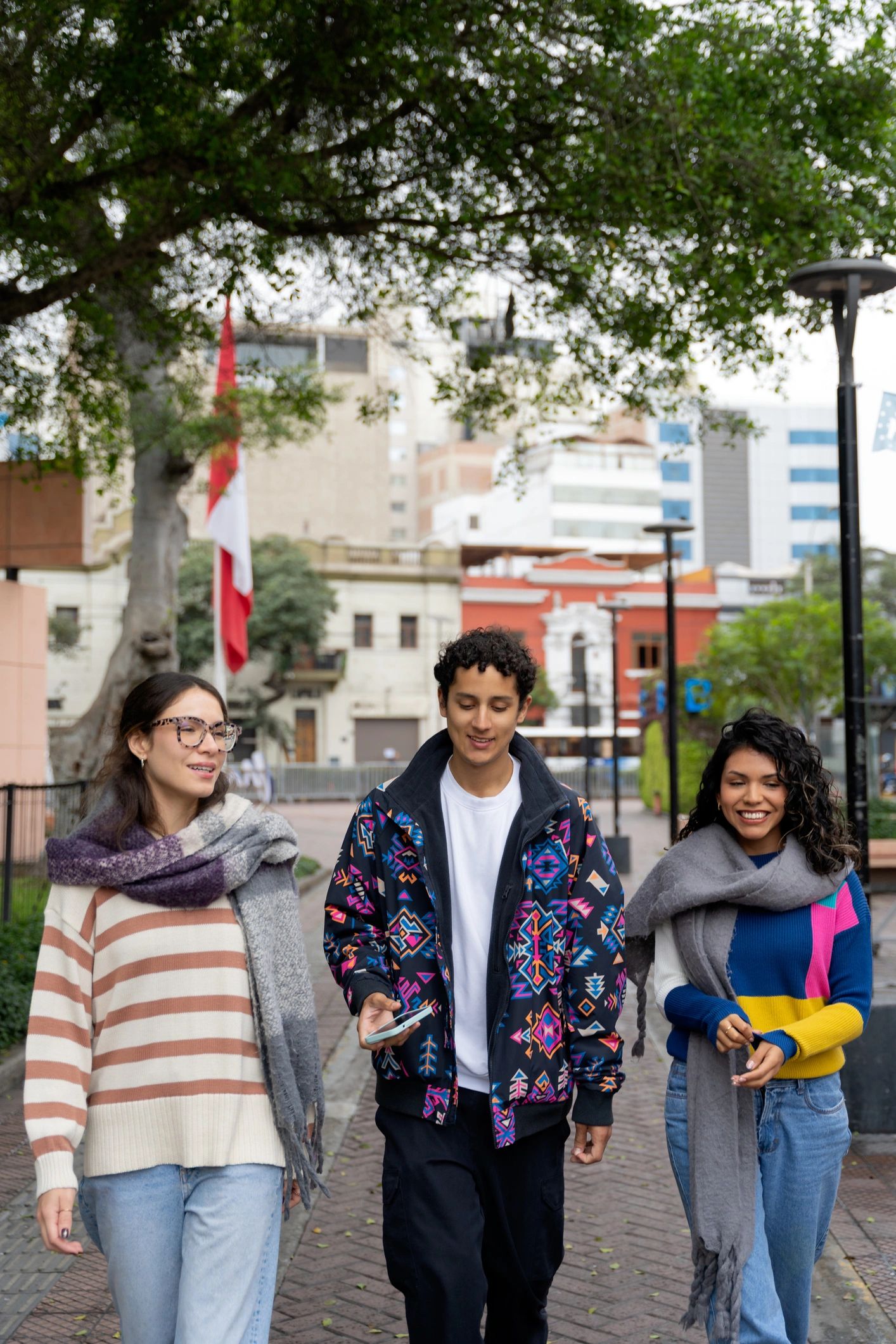 Three friends walking through a city center