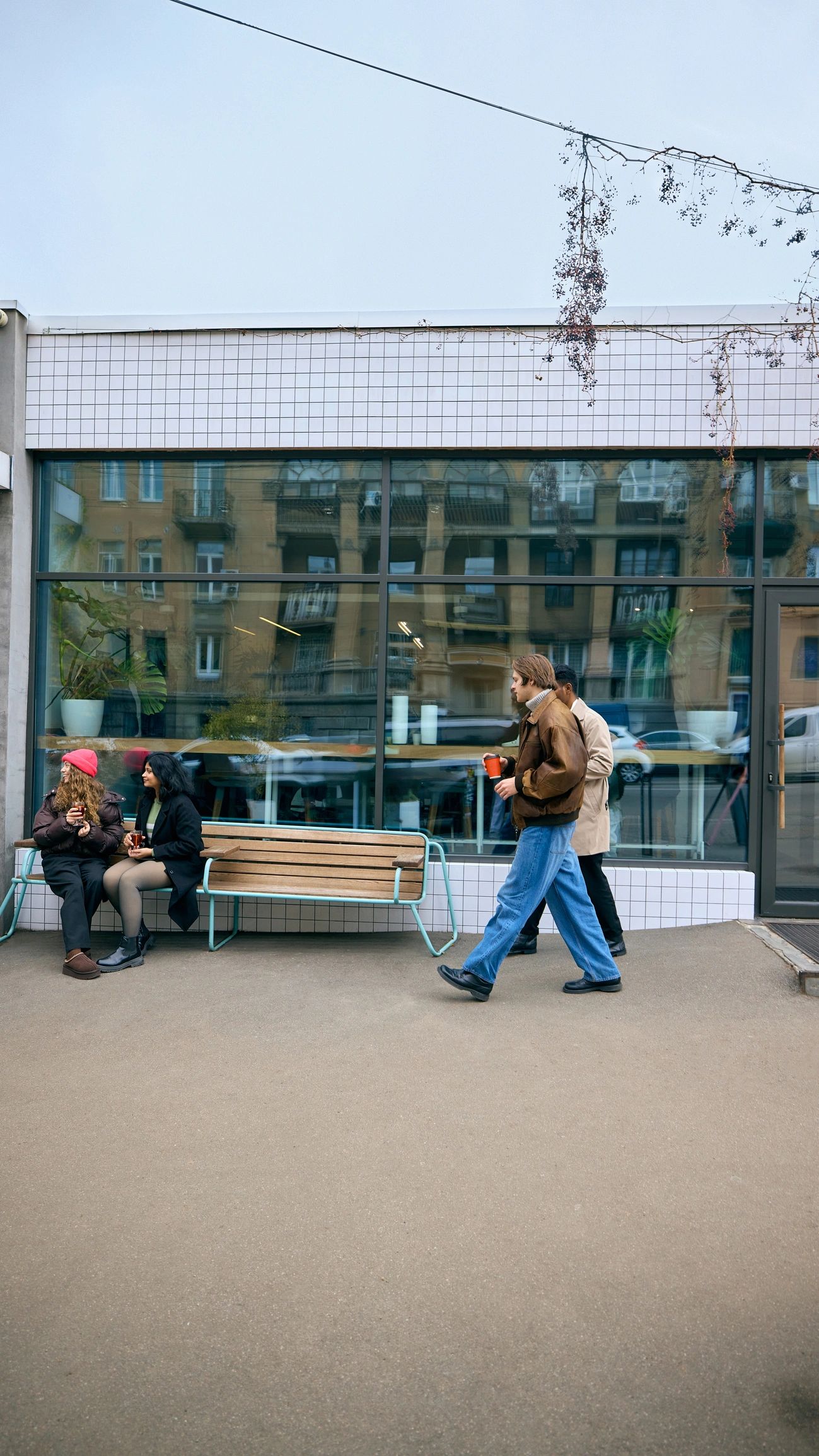 People outdoors with hot drinks in a winter city setting